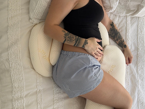 Pregnant woman lying carefully on her side in bed managing pelvic girdle pain during pregnancy