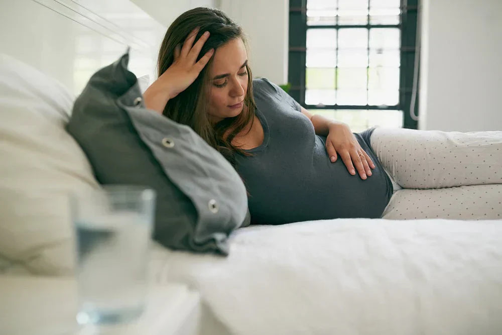 Pregnant woman resting hands on her bump in a calmly