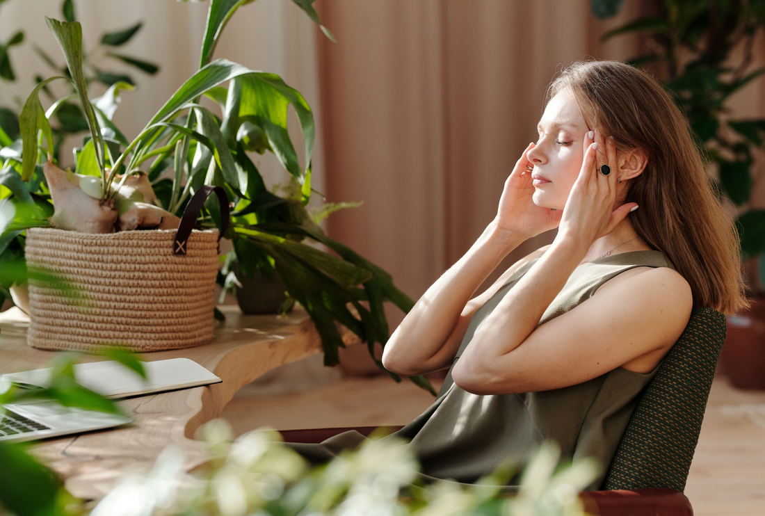 Pregnant woman sitting calmly at home with hand resting at her temple experiencing a pregnancy headache