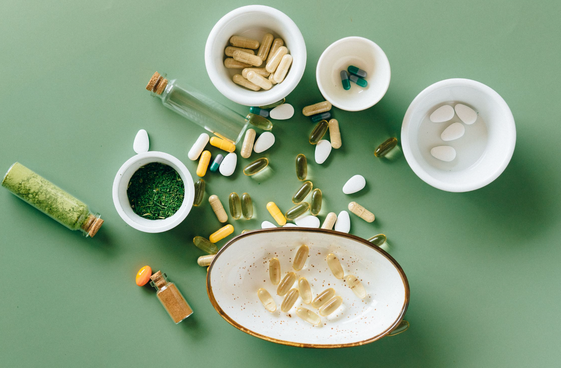 Pregnancy supplements and fresh whole foods arranged on a neutral surface in natural light