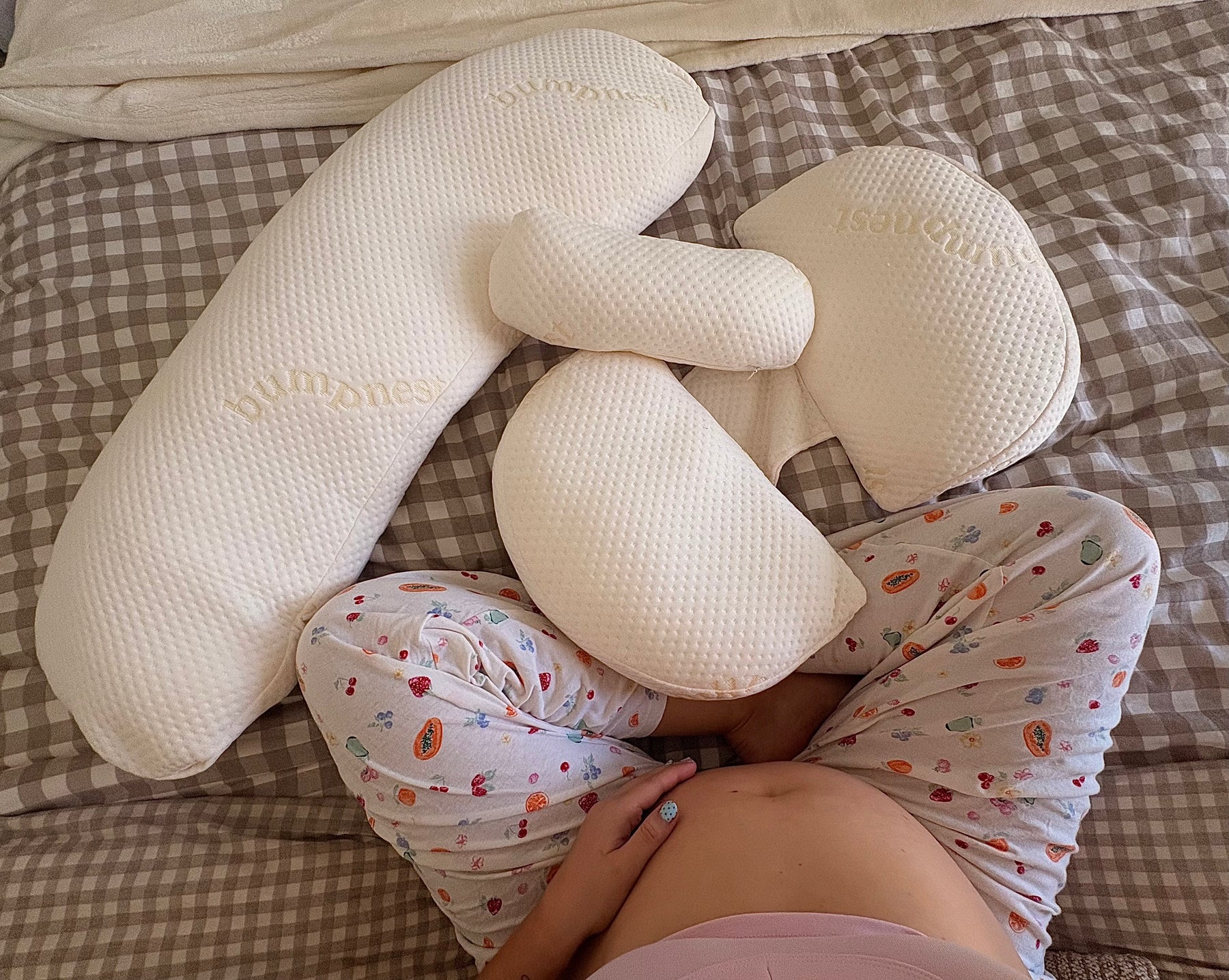 Pregnant woman sleeping on her side with the BumpNest maternity pillow