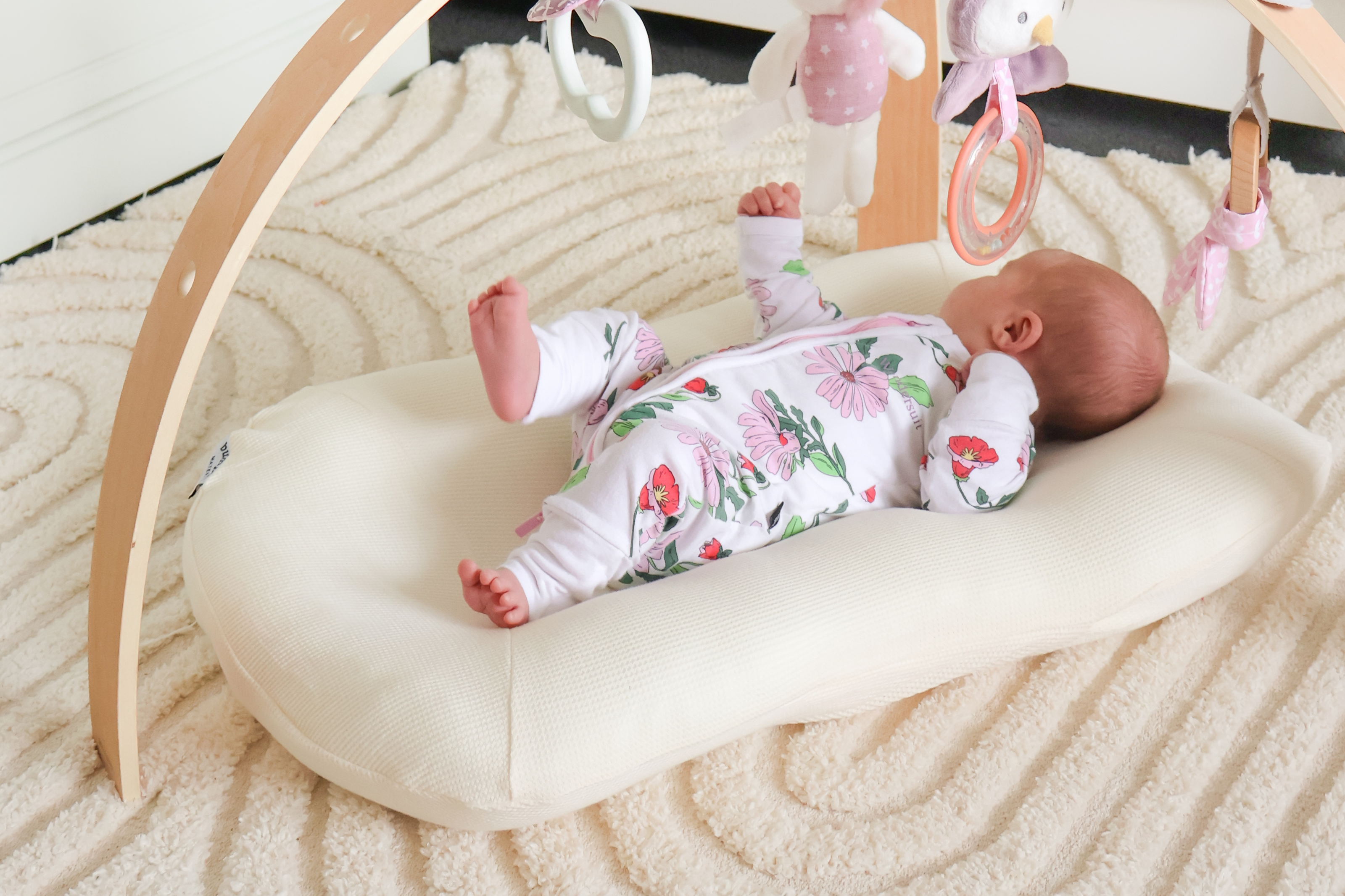 Australian newborn baby enjoying activity gym play while resting in Bumpnest Baby Pod lounger
