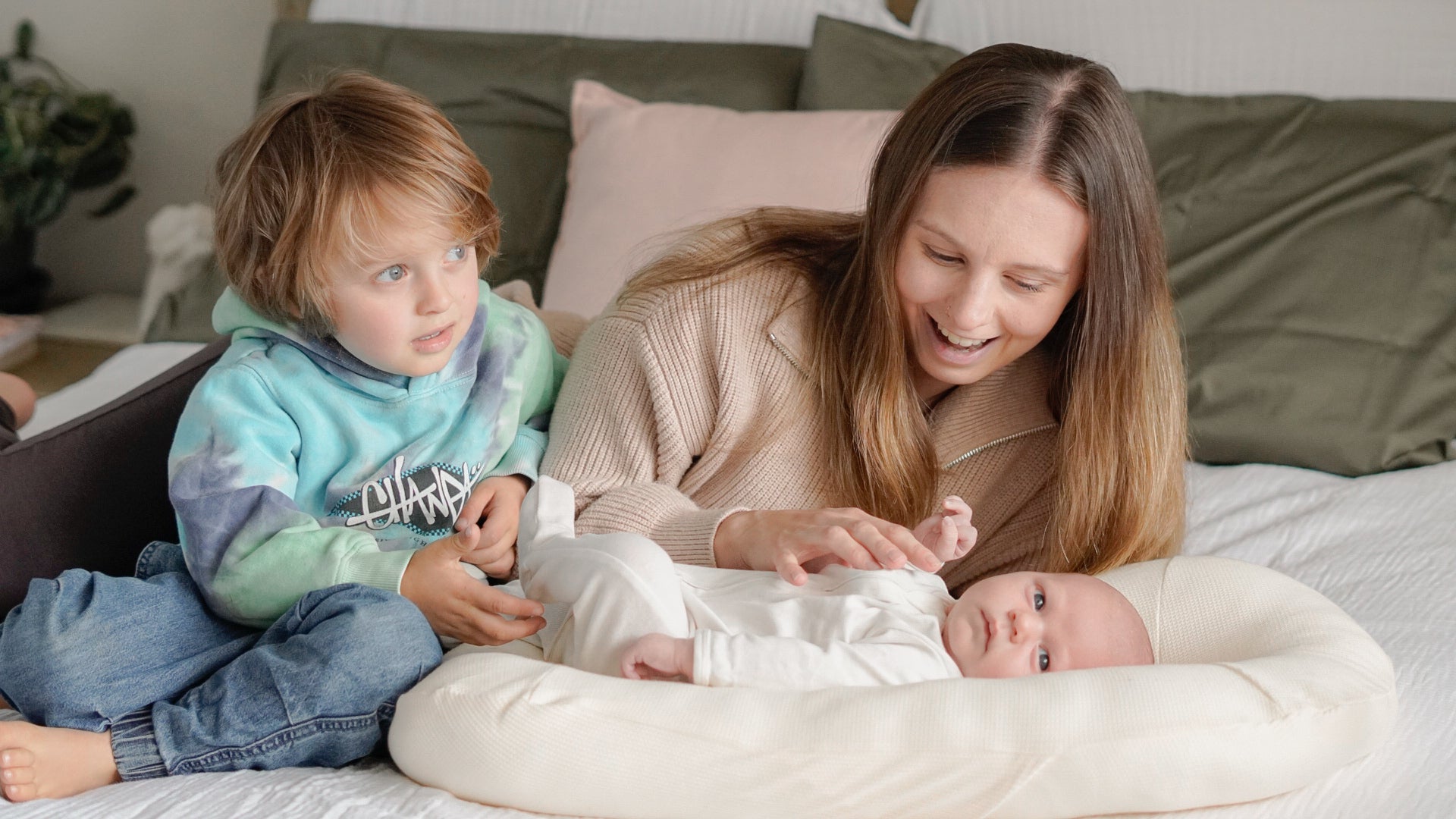 Mum and toddler playing with newborn baby resting safely in Bumpnest Baby Pod during family time