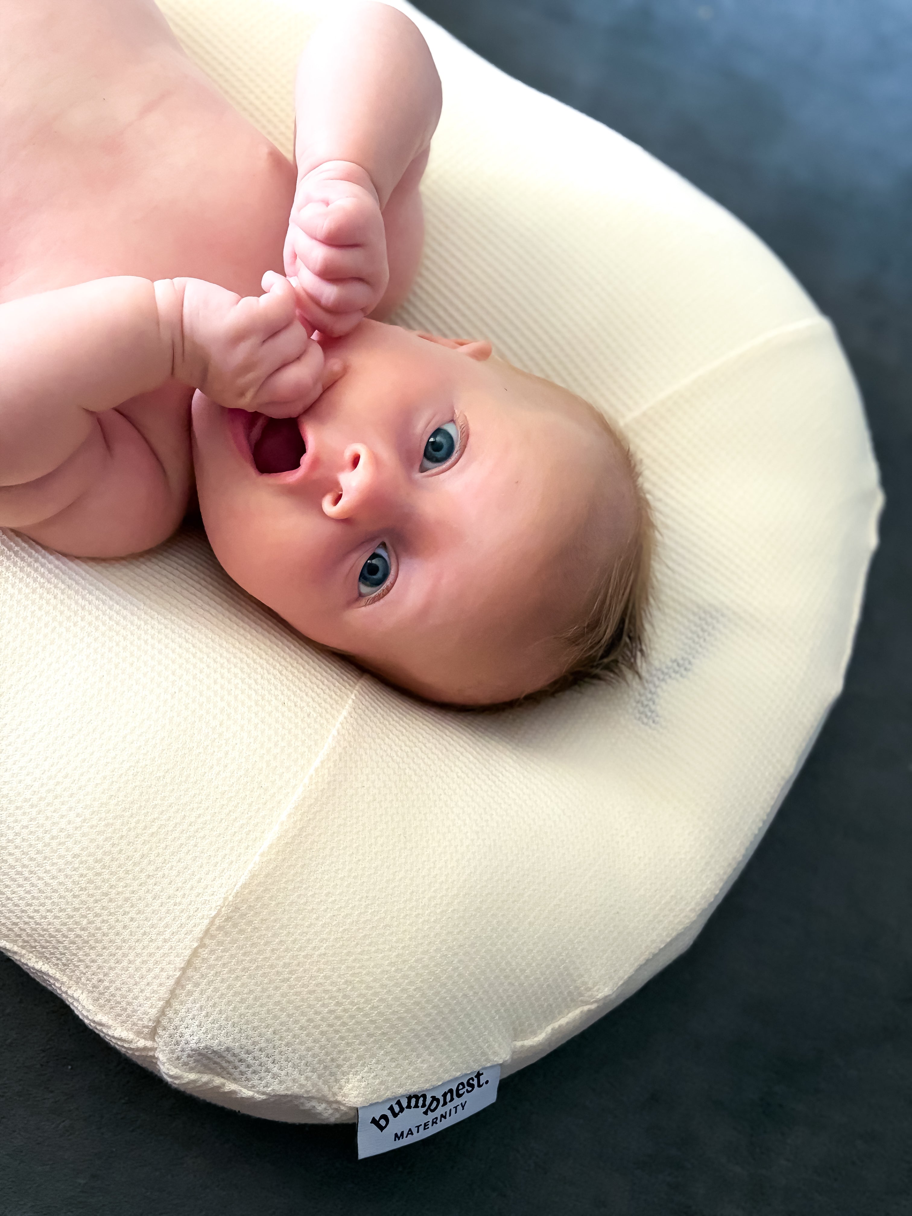 Newborn baby lying snug and settled in Bumpnest Baby Pod lounger with waffle cotton cover